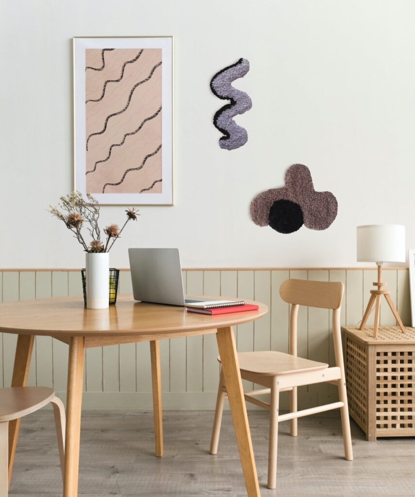 Minimalistische Küche mit Holzmöbeln und an der Wand sind geometrische Wandteppiche.